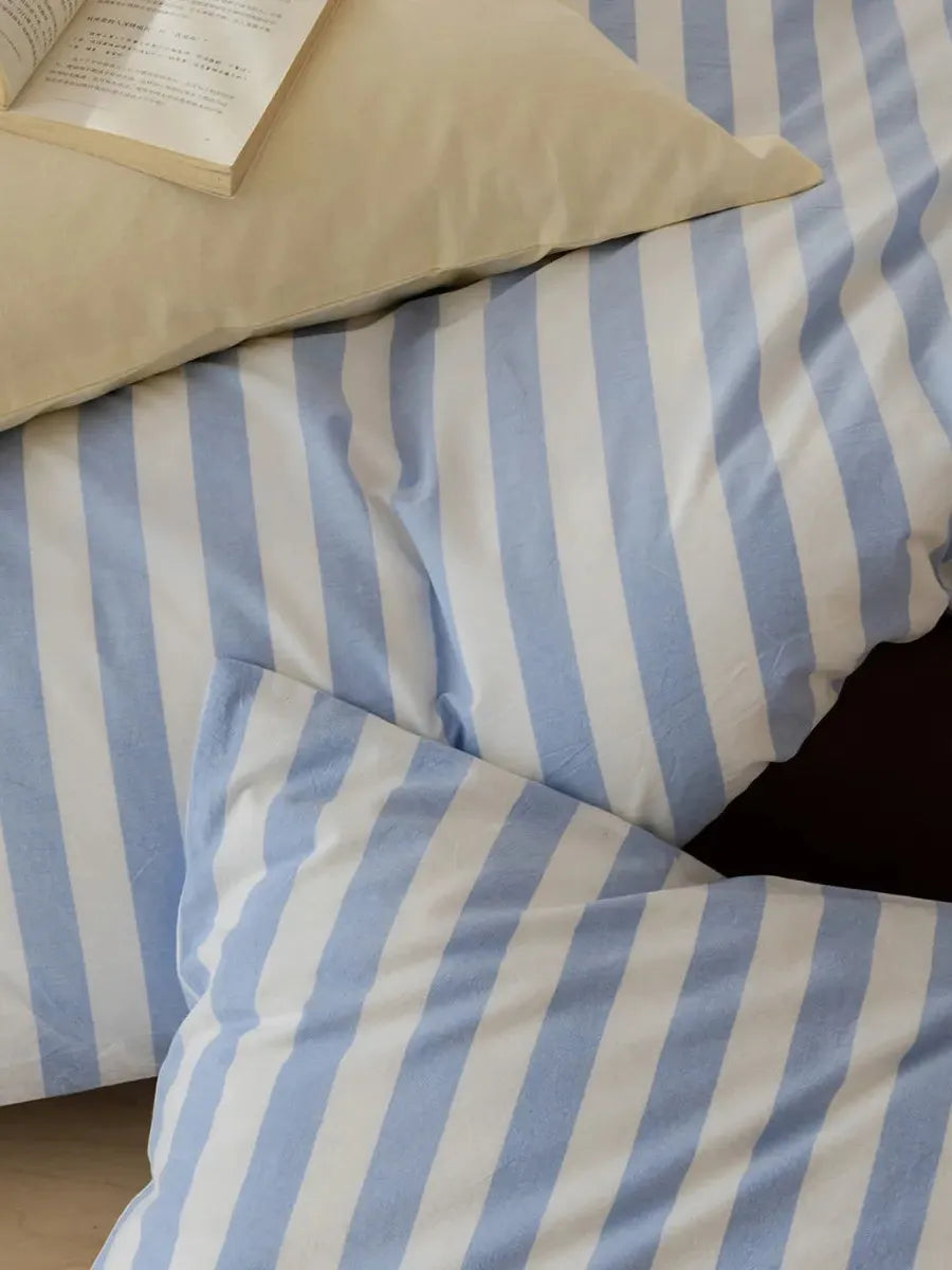 Mixed blue striped bedding set by Breezora featuring a duvet cover, pillowcases, and a textured design.