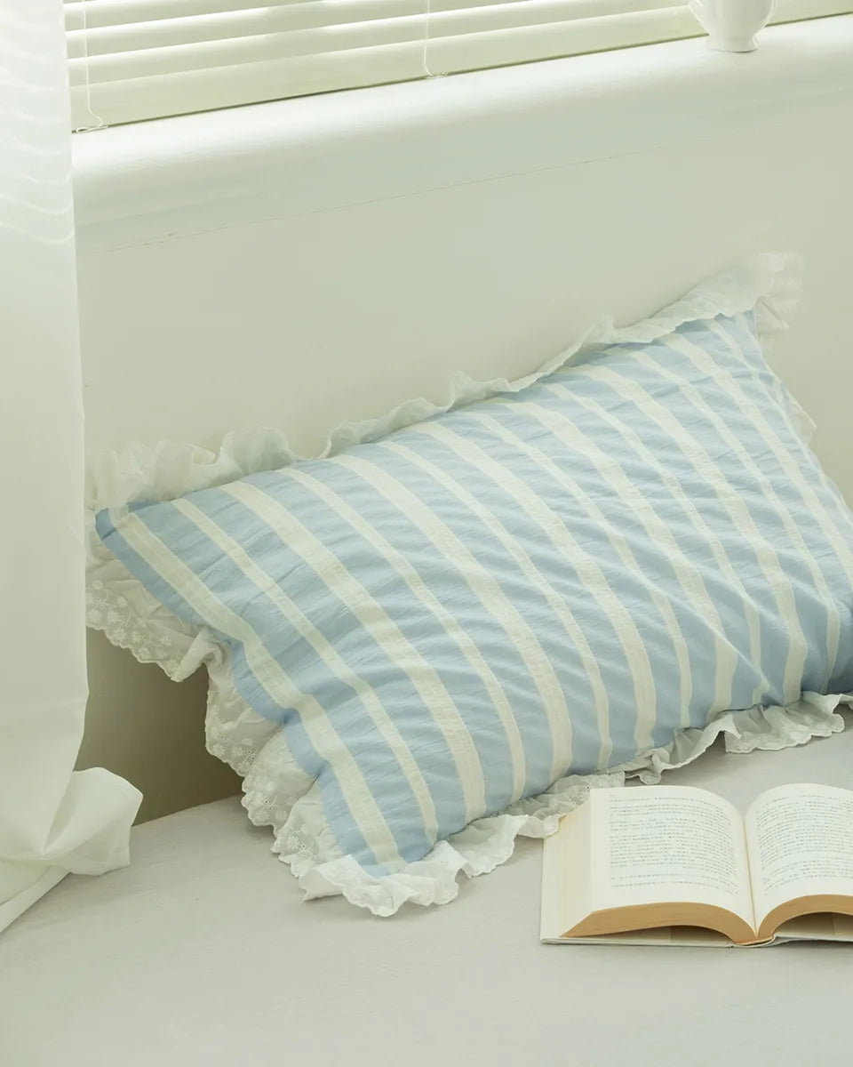 Breezora striped jacquard bedding set featuring a lace ruffle detail, elegantly draped on a bed.